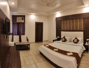 a hotel room with a large bed and a chair at Hotel Krishna in Katra