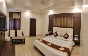 a hotel room with a bed and a chair at Hotel Krishna in Katra