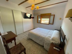 a bedroom with a bed and a table and a window at Hotel Rural Sierra De Segura in Puente de Génave