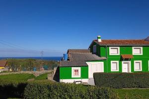 una casa verde y blanca en una colina en La Casa Verde, 
