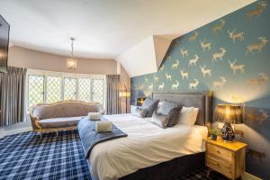 - une chambre avec un lit et un mur orné d'une fresque murale représentant des cerfs dans l'établissement Kettleburgh Chequers, à Kettleburgh