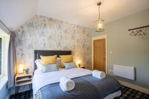 a bedroom with a large bed with towels on it at Kettleburgh Chequers in Kettleburgh