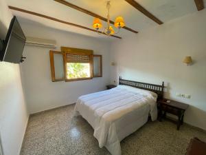 1 dormitorio con cama blanca y ventana en Hotel Rural Sierra De Segura, en Puente de Génave