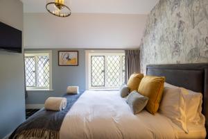 een slaapkamer met een groot wit bed met gele kussens bij Kettleburgh Chequers in Kettleburgh