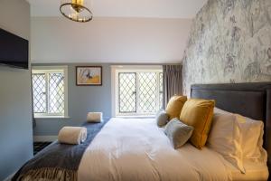 a bedroom with a large white bed with yellow pillows at Kettleburgh Chequers in Kettleburgh