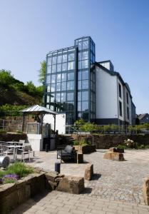 a large glass building with a patio in front of it at Hotel am Markt in Wipperfürth