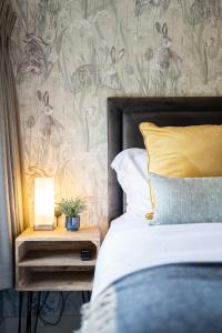 een slaapkamer met een bed en een nachtkastje met een lamp bij Kettleburgh Chequers in Kettleburgh