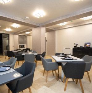 a dining room with tables and chairs and a screen at Hotel Del Ponte in Târgovişte