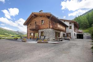 a large wooden house on a dirt road at Agriturismo Bosco d'oro 2 in Livigno