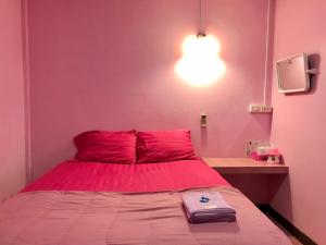 um quarto rosa com uma cama com uma parede rosa em แสงสง่ารีสอร์ท Saeng Sa-Nga Resort 