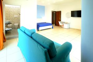 a living room with a blue couch and a bed at Donna Elena B&B in Naples