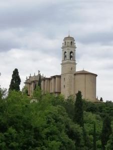 um edifício no topo de uma colina com uma torre de relógio em Due Magnolie em Monzambano