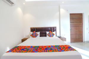 a bedroom with a large bed with a colorful blanket at FabHotel Bhawana in Agra