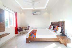 a bedroom with a bed and a table with chairs at FabHotel Bhawana in Agra