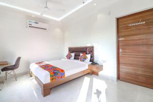 a bedroom with a bed and a wooden door at FabHotel Bhawana in Agra