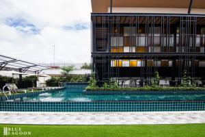 a swimming pool in front of a building at Blue Lagoon Hotel in Chiang Rai