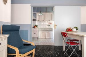 een keuken met witte kasten en een rode stoel bij Raffaello House in Sestri Levante