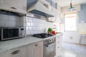 een keuken met een fornuis en een magnetron bij Raffaello House in Sestri Levante