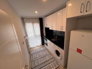 una piccola cucina con lavandino e frigorifero di PURPLE VIP SUITE a Trabzon