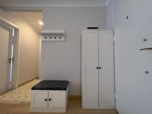 PURPLE VIP SUITE في طرابزون: غرفة بها دواليب بيضاء وكرسي أسود