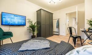 1 dormitorio con 1 cama y TV en la pared en Arbio I Cozy Apartment Augsburg-Göggingen en Augsburg