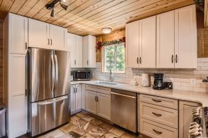 uma cozinha com armários brancos e um frigorífico de aço inoxidável em Gasthaus Breck home em Breckenridge