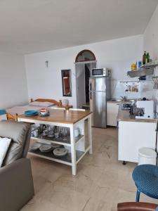 a kitchen with a table in the middle of a room at Shabby chic beach cottage Hvar in Hvar