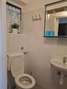 a white bathroom with a toilet and a sink at Shabby chic beach cottage Hvar in Hvar
