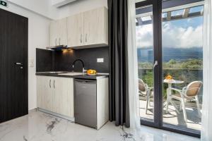 a kitchen with a sink and a table with chairs at Kataleya Poolside Suites in Skala Potamias