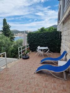 a patio with chairs and a table and an umbrella at Shabby chic beach cottage Hvar in Hvar