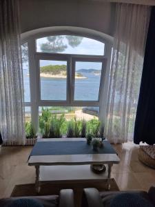 a living room with a large window and a table at Shabby chic beach cottage Hvar in Hvar
