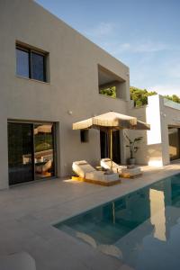 une maison avec une piscine et un parasol dans l'établissement Merelia Exclusive Villas, à Parga
