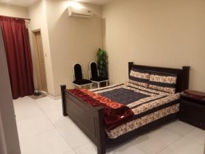 a bedroom with a bed with two chairs in it at Hotel Seven Eleven in Lahore