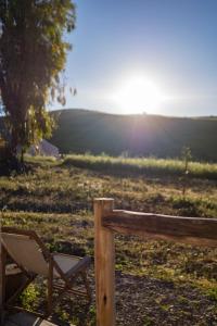 une chaise assise à côté d'une clôture en bois dans l'établissement Tienda de Safari Almagro, à Montecorto