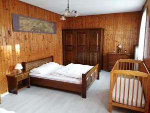 ein Schlafzimmer mit einem Bett und einer Holzwand in der Unterkunft Maison au coeur de la campagne jurassienne in Beauvoisin