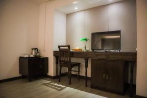 a desk with a television and a chair in a room at Villa Lantara Chiangmai in Chiang Mai +130 photos