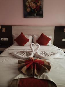 two swans made out of towels on a bed at Hotel Krishna Kathmandu in Kathmandu