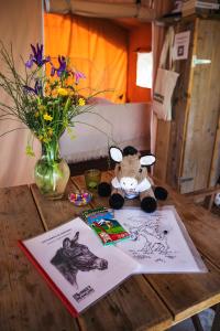 a stuffed animal sitting on a table with a vase of flowers at Tienda de Safari Almagro in Montecorto