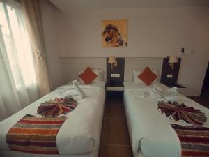 Dos camas en una habitación de hotel con lazos de arco en Hotel Krishna Kathmandu en Katmandú