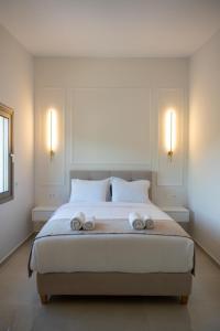 1 dormitorio con 1 cama grande y 2 toallas. en Merelia Exclusive Villas, en Parga