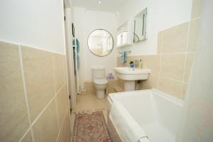 een badkamer met een wastafel, een toilet en een spiegel bij Studio Apartment in Central Bath in Bath