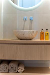 - un lavabo dans la salle de bains avec un bol sur une étagère dans l'établissement Merelia Exclusive Villas, à Parga