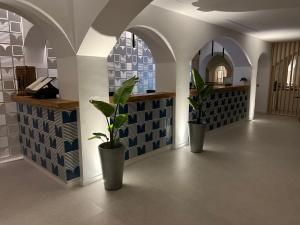 un corridoio con due piante in vaso in un edificio di Hotel La Torre a Palinuro