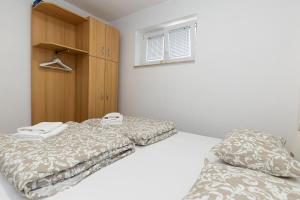 a bedroom with two beds and a cabinet at Andrea&Goran in Selce