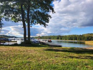 a dock on a lake with boats in the water at Duży dom Wilkasy Zalesie 100m od plaży in Wilkasy