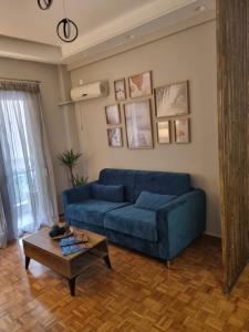 a living room with a blue couch and a coffee table at Piraeus open view Appartment in Piraeus