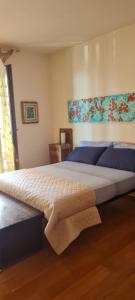 a bedroom with a large bed with blue sheets at Alice e la sua casa in Agrigento