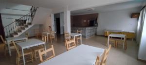 a room with tables and chairs and a kitchen at Serrana Gerês in Geres