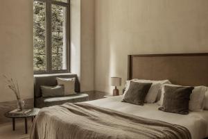 een slaapkamer met een groot bed en een stoel bij MANNA in Valtessiniko 