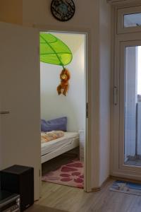 Cette chambre comprend un lit et un parasol vert. dans l'établissement Appartement "Weitblick", à Heiligenhafen
